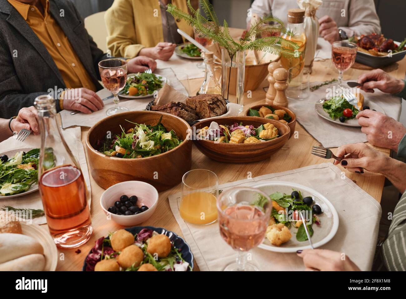 Vue rapprochée de la table à manger avec plats, boissons et personnes assis à la table et manger Banque D'Images