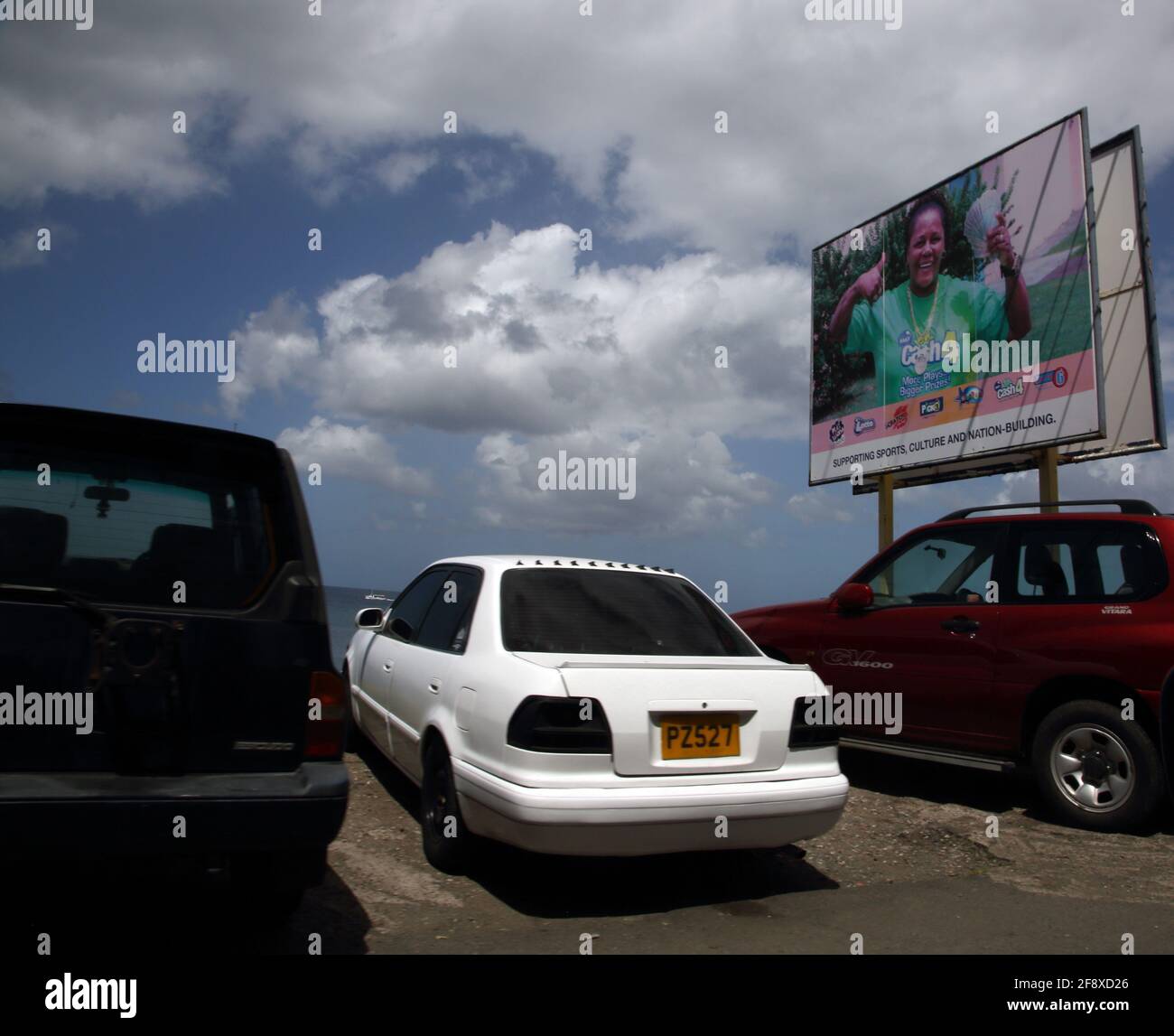 St George Grenada Cars in car Park by Billboard surplombant La mer Banque D'Images