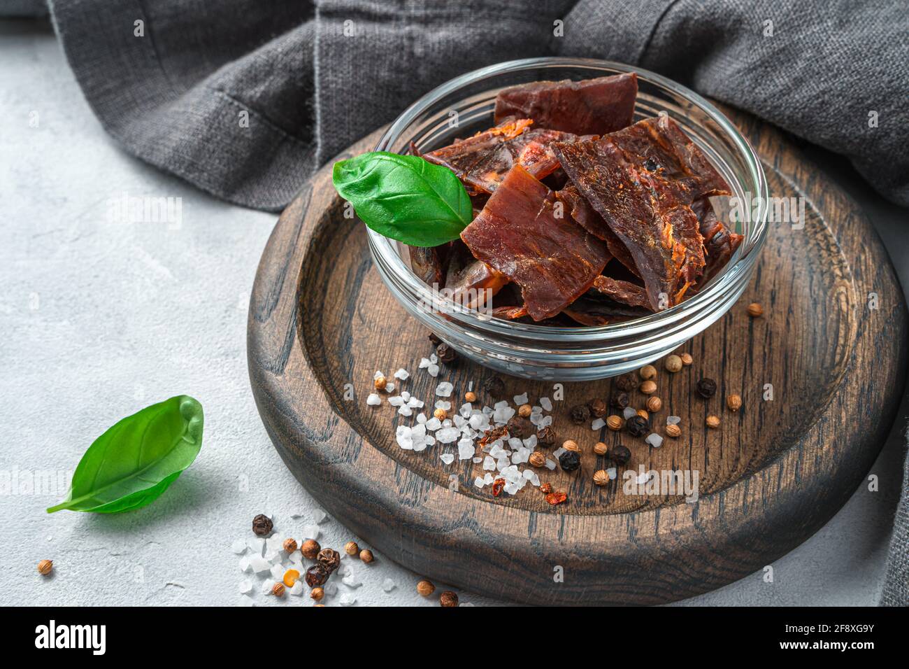 Une portion de viande séchée au poivre, au sel et au basilic frais sur fond  gris. Vue latérale, gros plan Photo Stock - Alamy