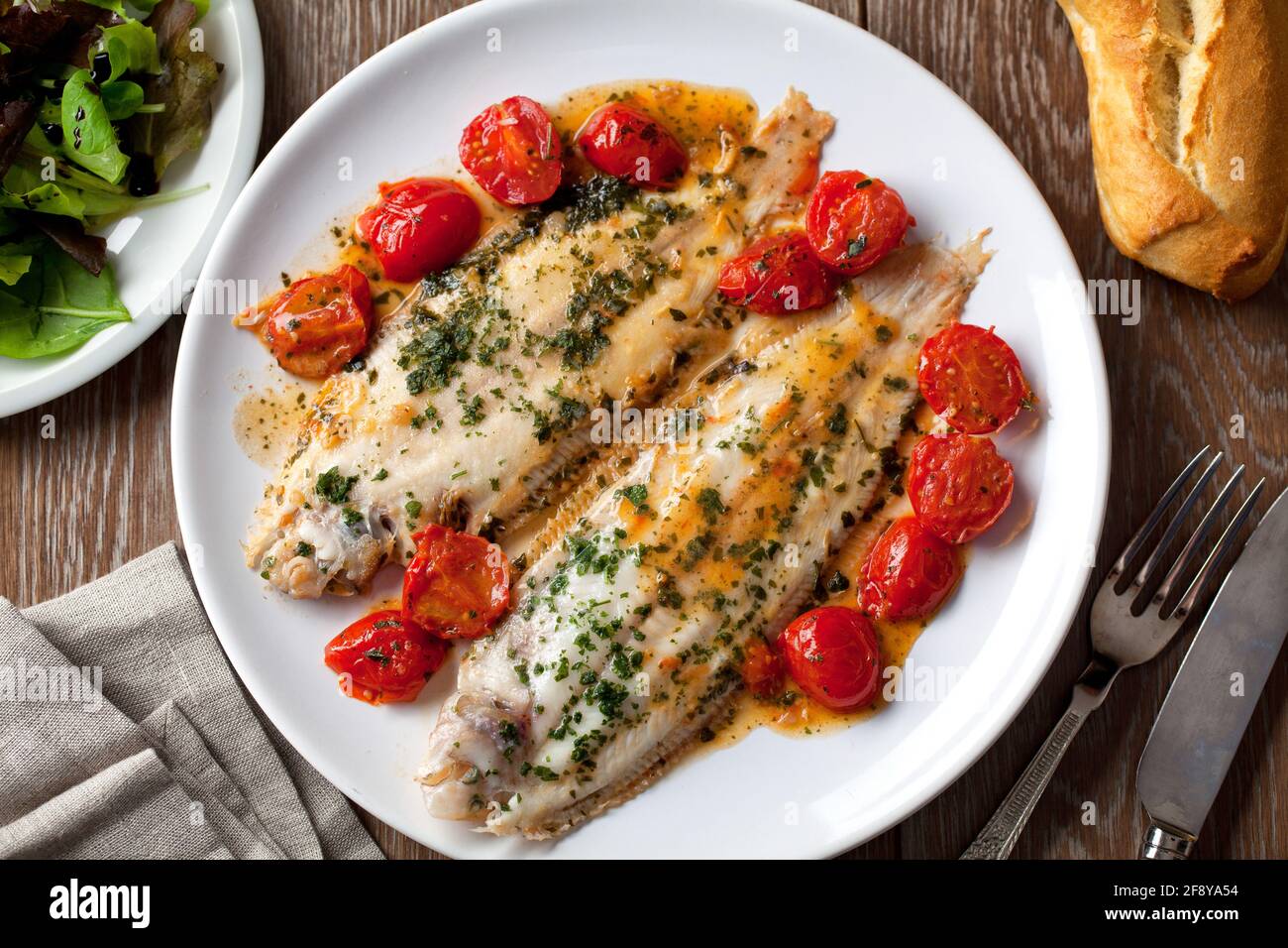 Sole avec tomates cerises sur une assiette. Photo de haute qualité. Banque D'Images