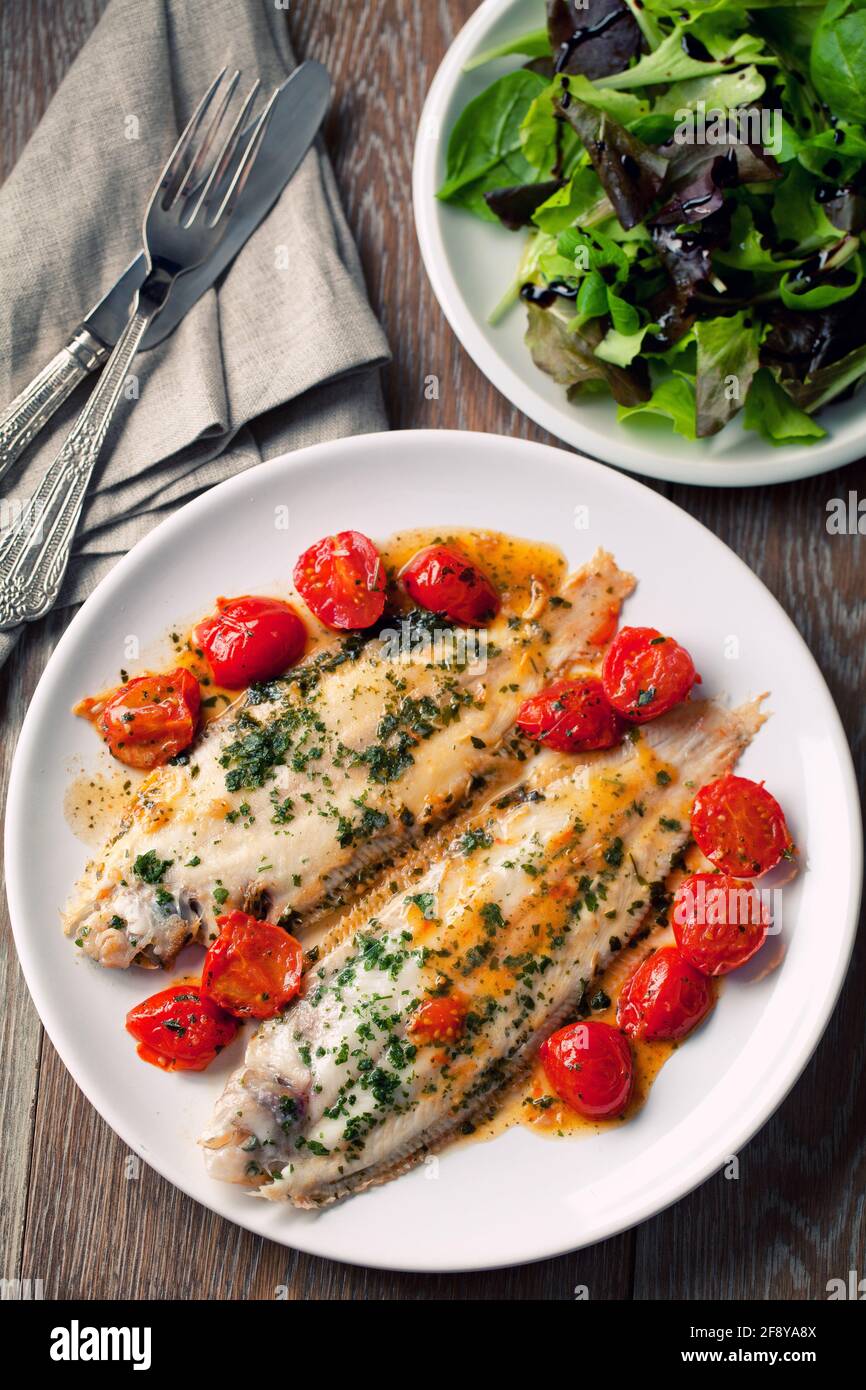 Sole avec tomates cerises sur une assiette. Photo de haute qualité. Banque D'Images