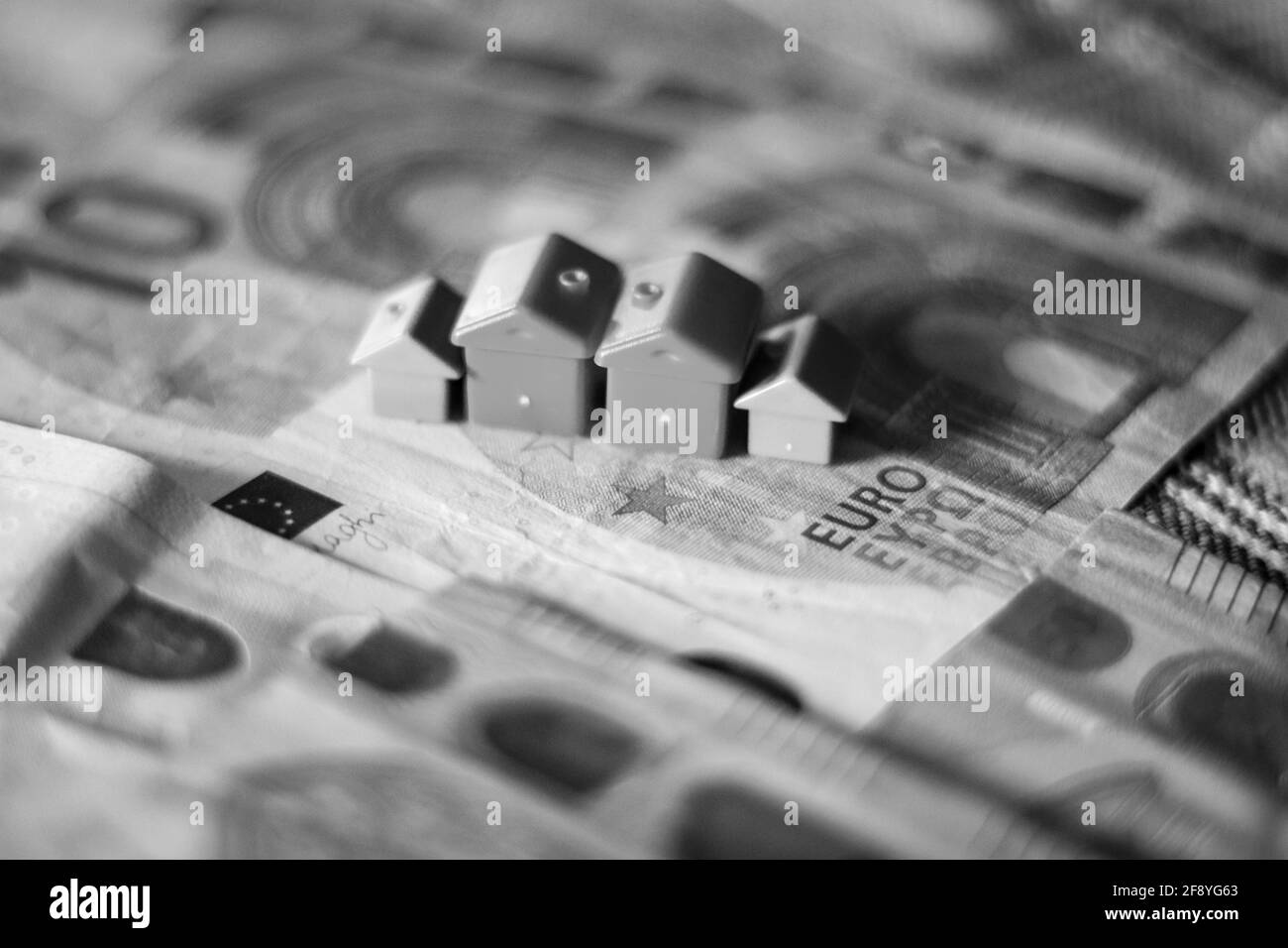 Tableau recouvert de billets en euros avec des maisons en haut. Concept d'investissement immobilier Banque D'Images