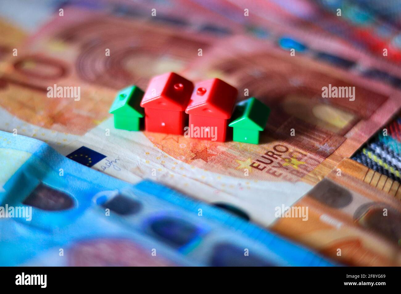 Tableau recouvert de billets en euros avec des maisons en haut. Concept d'investissement immobilier Banque D'Images