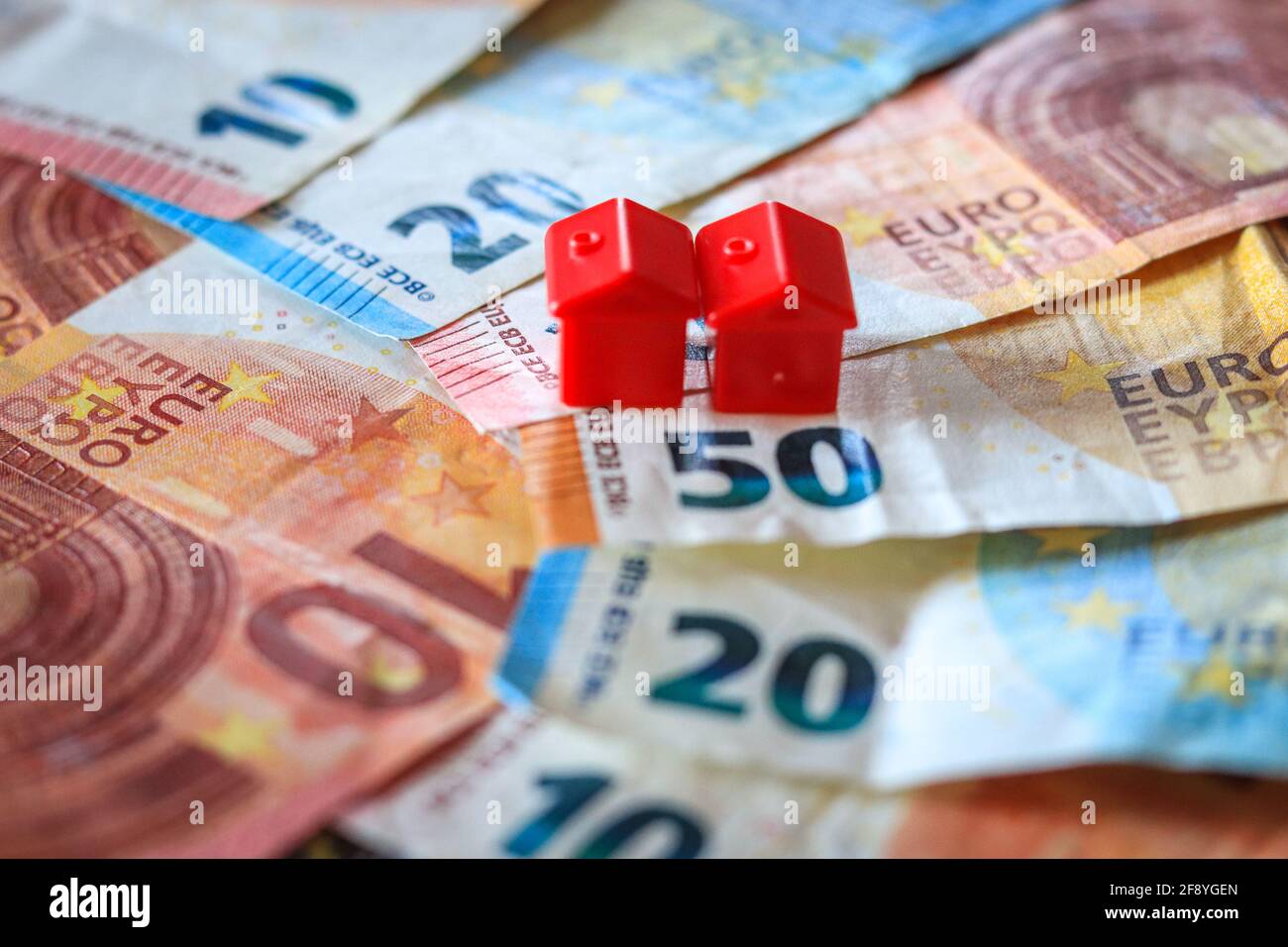 Tableau recouvert de billets en euros avec des maisons en haut. Concept d'investissement immobilier Banque D'Images