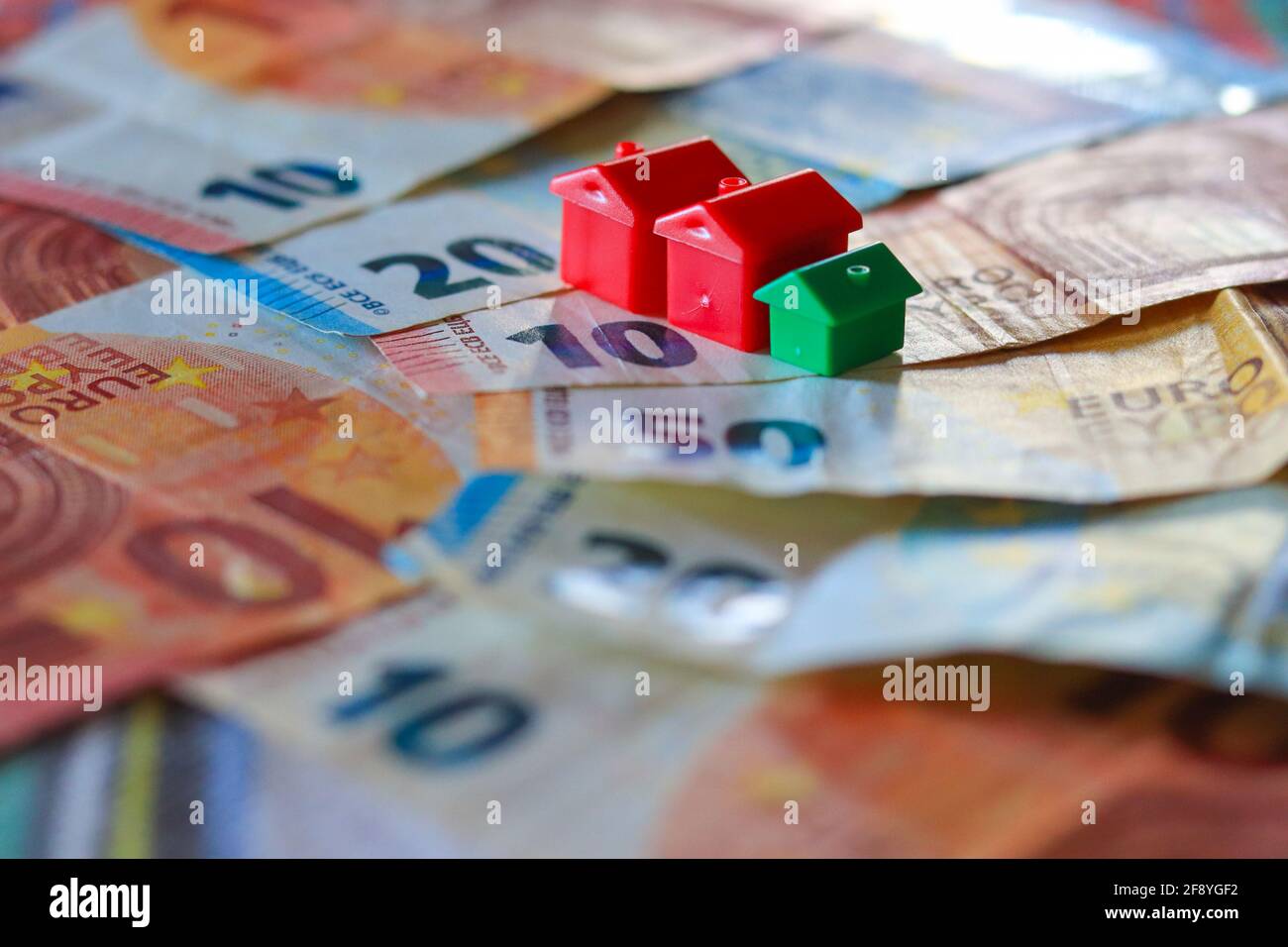Tableau recouvert de billets en euros avec des maisons en haut. Concept d'investissement immobilier Banque D'Images