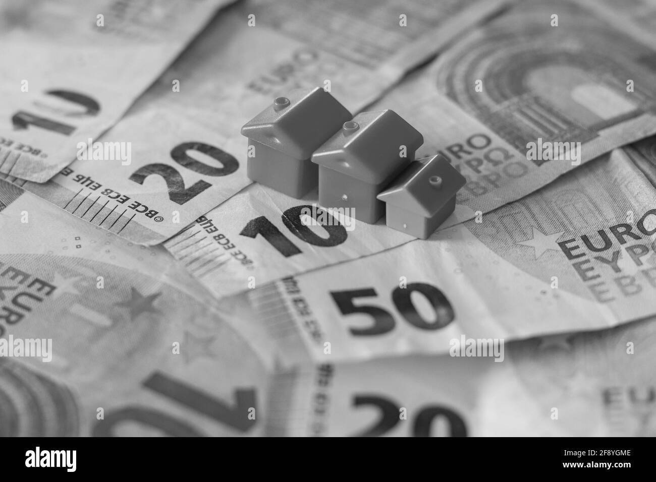 Tableau recouvert de billets en euros avec des maisons en haut. Concept d'investissement immobilier Banque D'Images