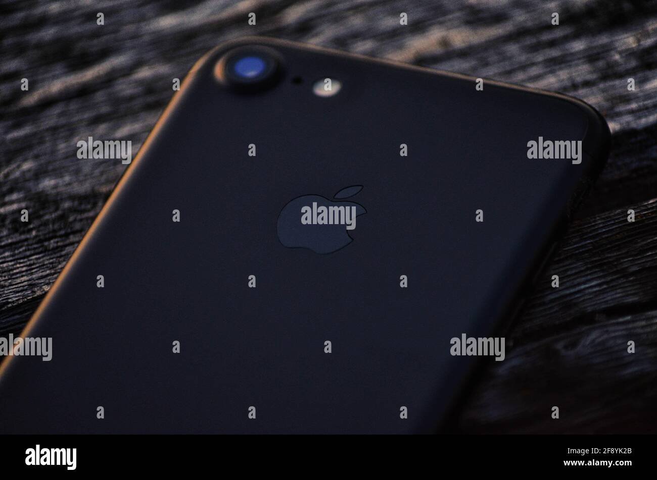 Je téléphone 8 avec coucher de soleil et fond en bois. Banque D'Images