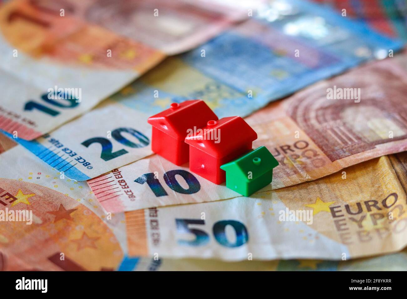 Tableau recouvert de billets en euros avec des maisons en haut. Concept d'investissement immobilier Banque D'Images