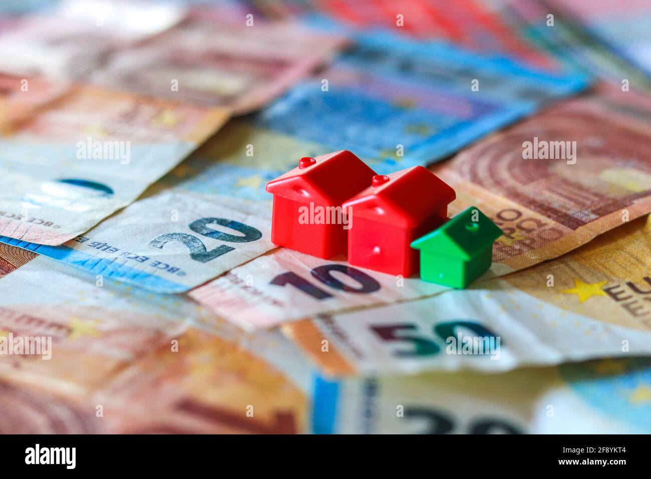 Tableau recouvert de billets en euros avec des maisons en haut. Concept d'investissement immobilier Banque D'Images