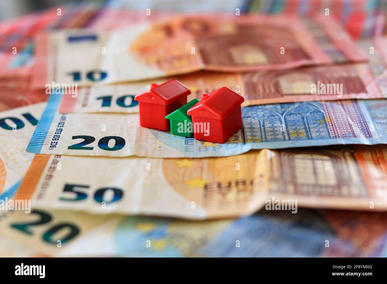 Tableau recouvert de billets en euros avec des maisons en haut. Concept d'investissement immobilier Banque D'Images