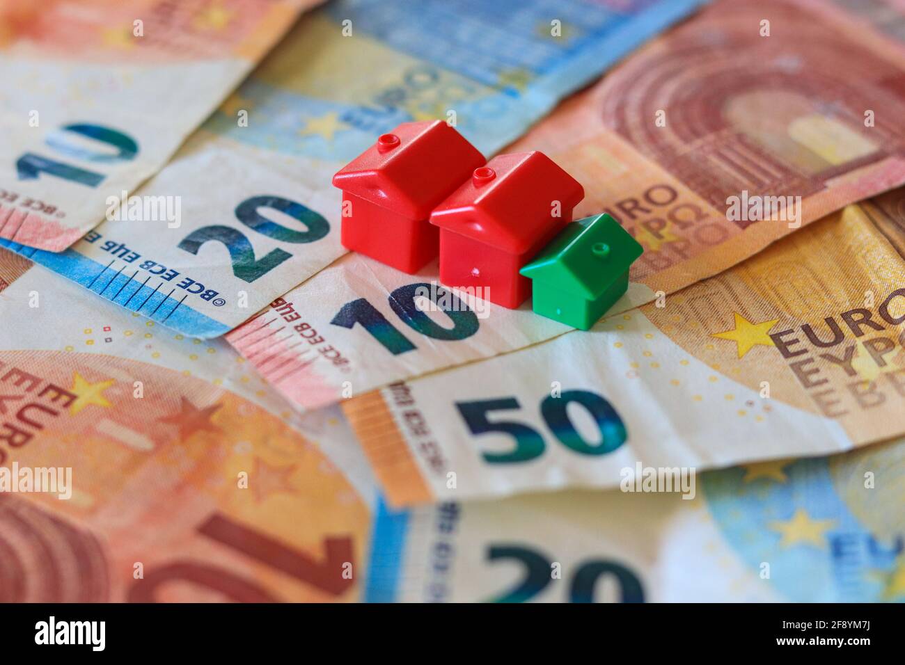 Tableau recouvert de billets en euros avec des maisons en haut. Concept d'investissement immobilier Banque D'Images