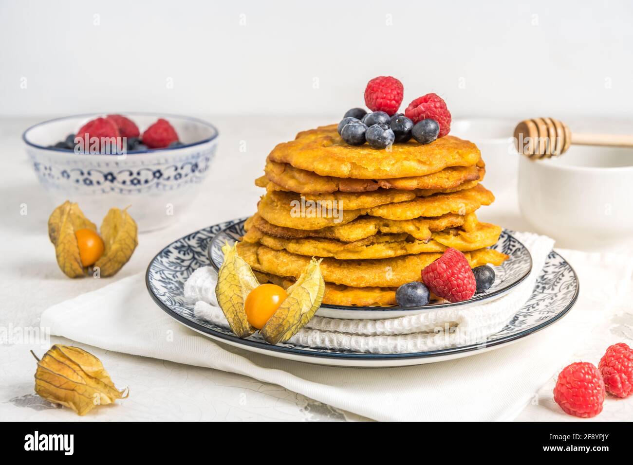 Pile de crêpes végétaliennes avec baies sur fond blanc, espace de copie Banque D'Images