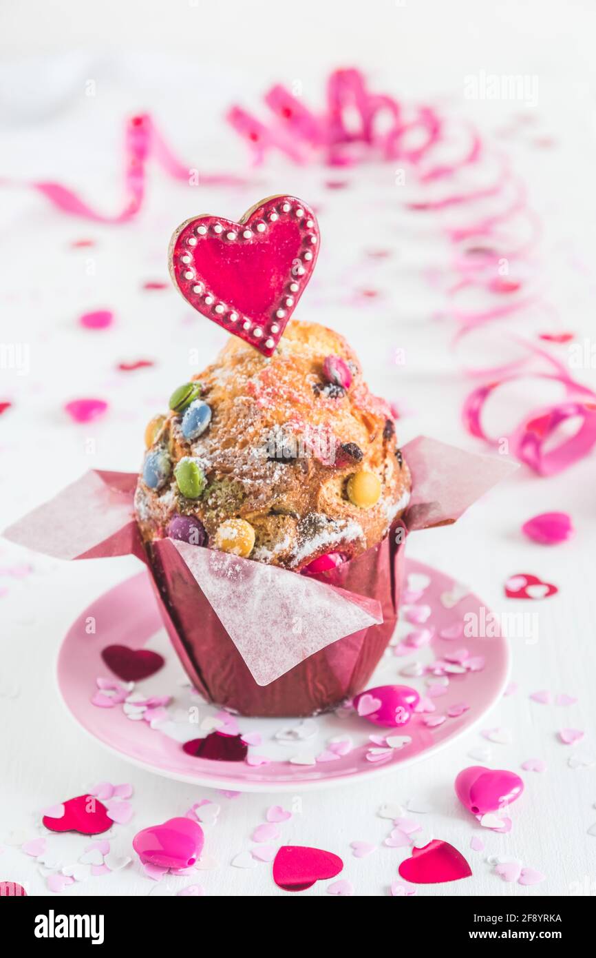 Cupcake aux grains de chocolat, décoré de coeurs rouges, roses et blancs pour l'anniversaire, la fête de la mère ou de la Saint-Valentin, fond blanc, vertical Banque D'Images