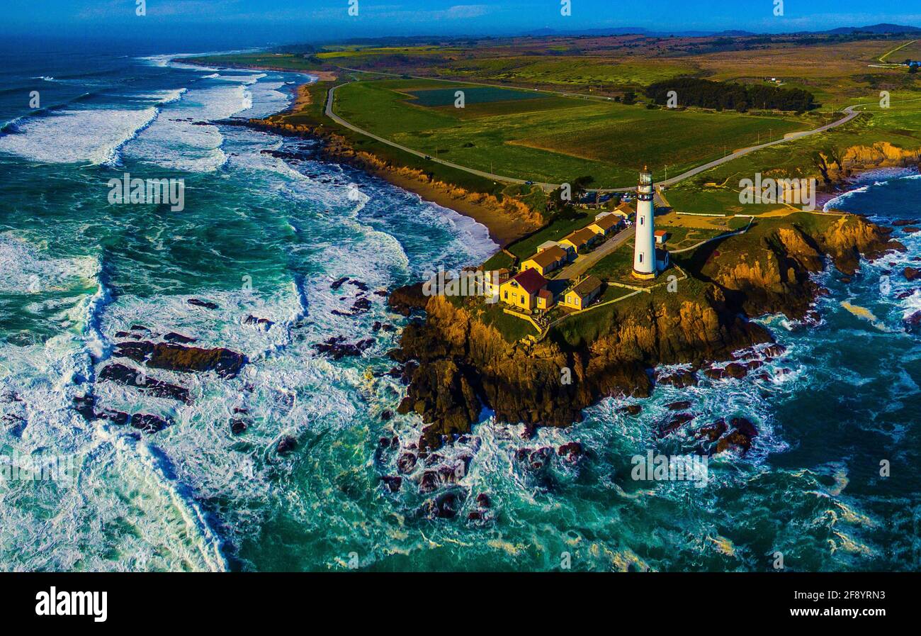 Vue aérienne des vagues s'écrasant contre les falaises avec le phare de Pigeon point, Pescadero, Californie, États-Unis Banque D'Images