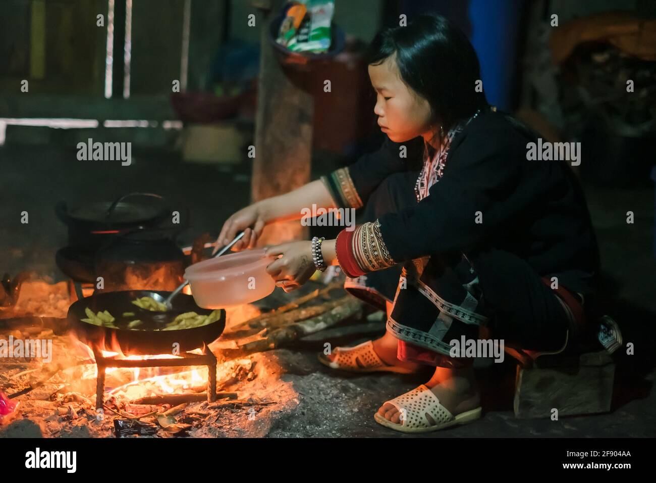Sapa, Vietnam - avril 14: Hmong, femme de la minorité ethnique dans des vêtements traditionnels cuisant de la nourriture sur le feu à la maison. Banque D'Images