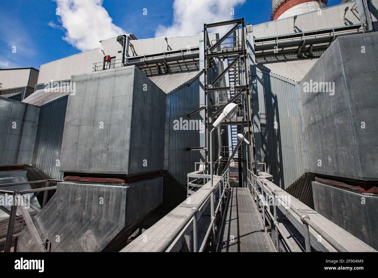 Centrale thermique GRES-1. Équipement de métal gris bunkers de charbon brut, pont et handrai. Vue abstraite de la centrale électrique. Ciel bleu et fumée. Banque D'Images