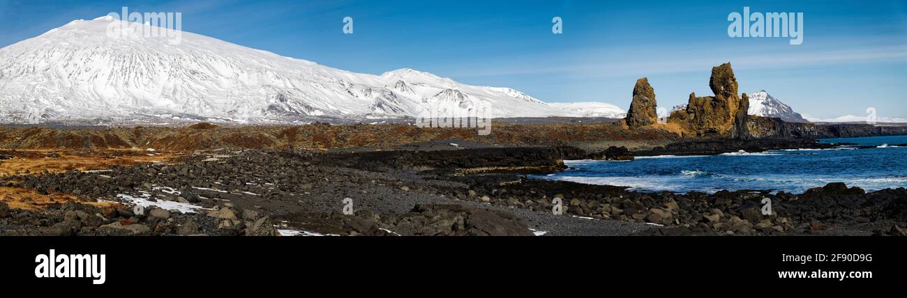 Paysage côtier aride avec colline enneigée, Islande Banque D'Images