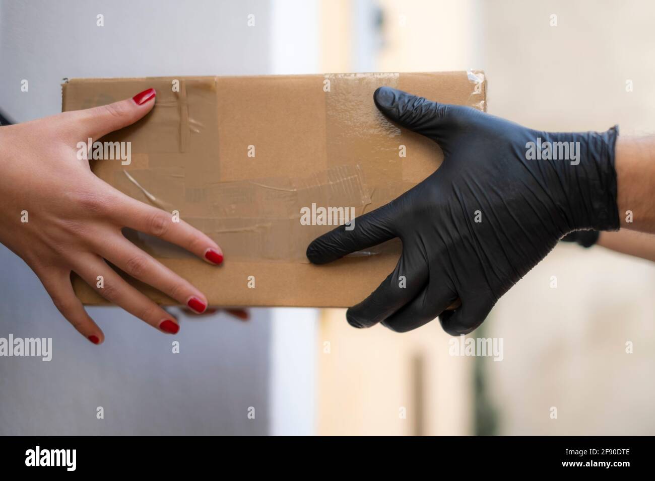 La femme reçoit à la maison le paquet d'expédition des hommes de livraison, commerce électronique acheter Banque D'Images