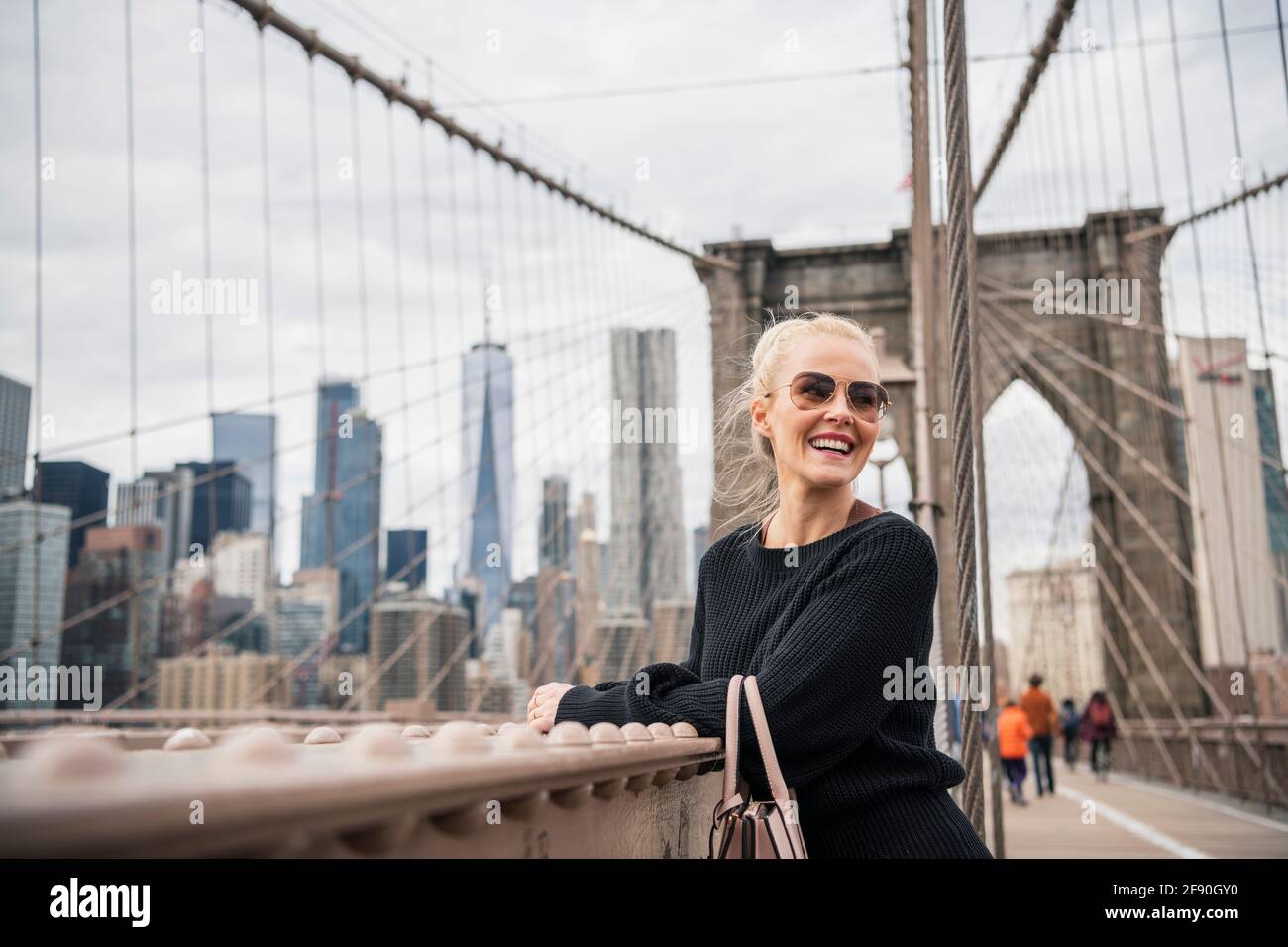 Enchantée touriste féminine penchée sur la rampe du pont Banque D'Images
