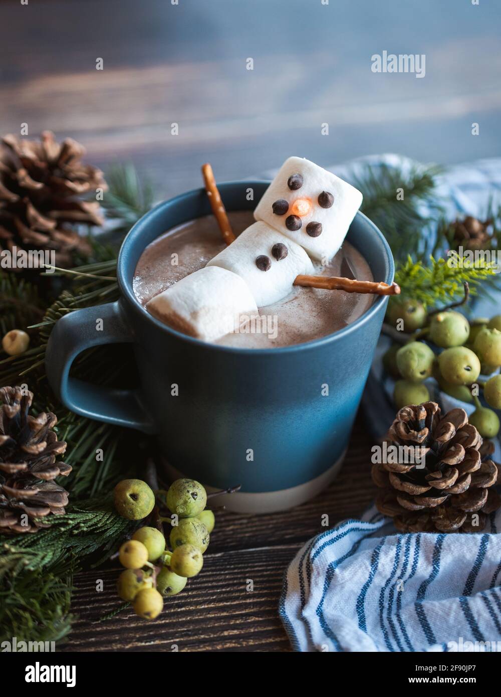 Bonhomme de neige en guimauve dans une tasse de chocolat chaud avec décor d'hiver. Banque D'Images