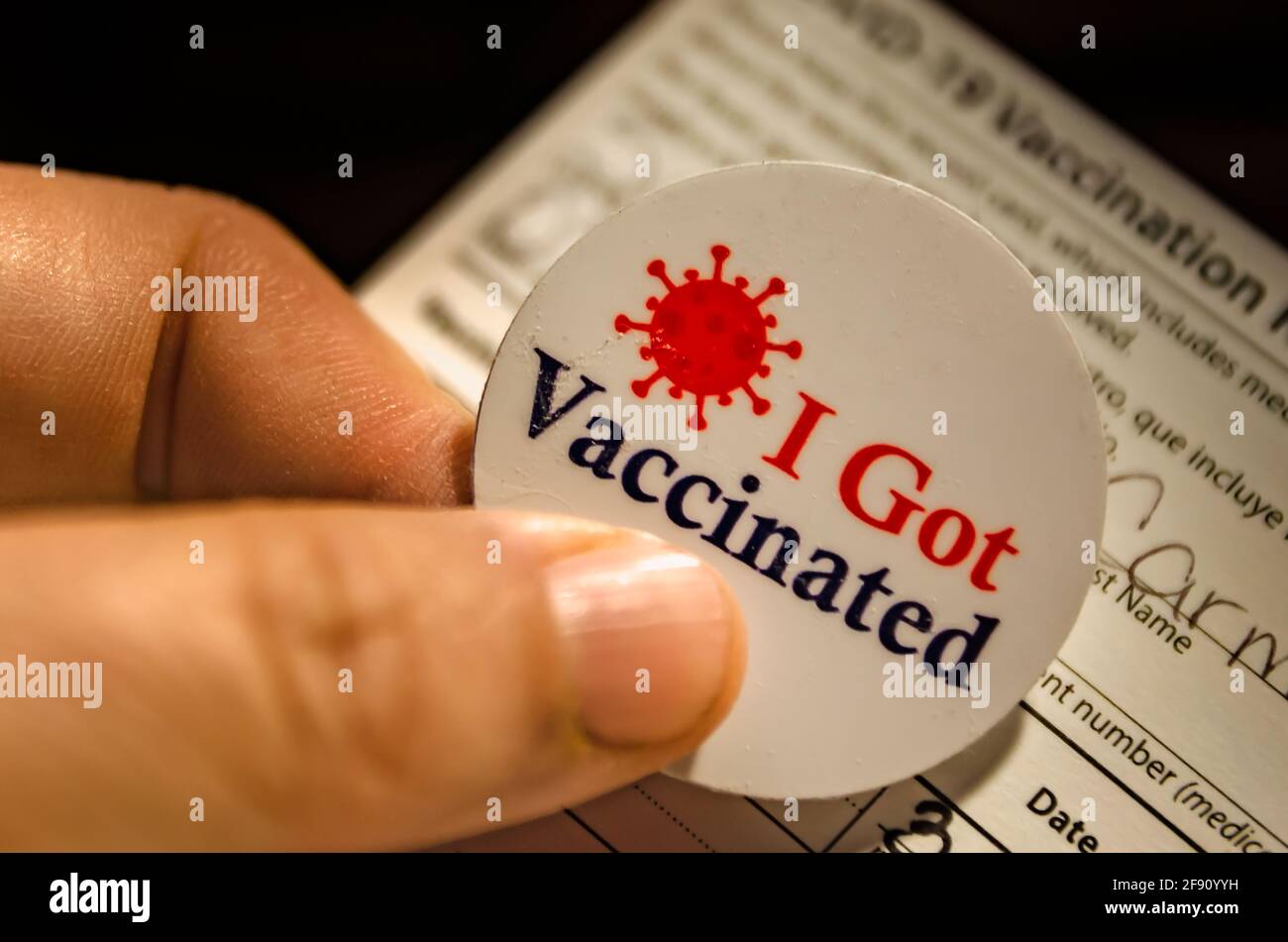 Un patient est détenteur d’un autocollant « J’ai été vacciné » et d’une carte de vaccination COVID-19 après avoir reçu le vaccin COVID-19 de Pfizer-BioNTech à Mobile, Alabama. Banque D'Images
