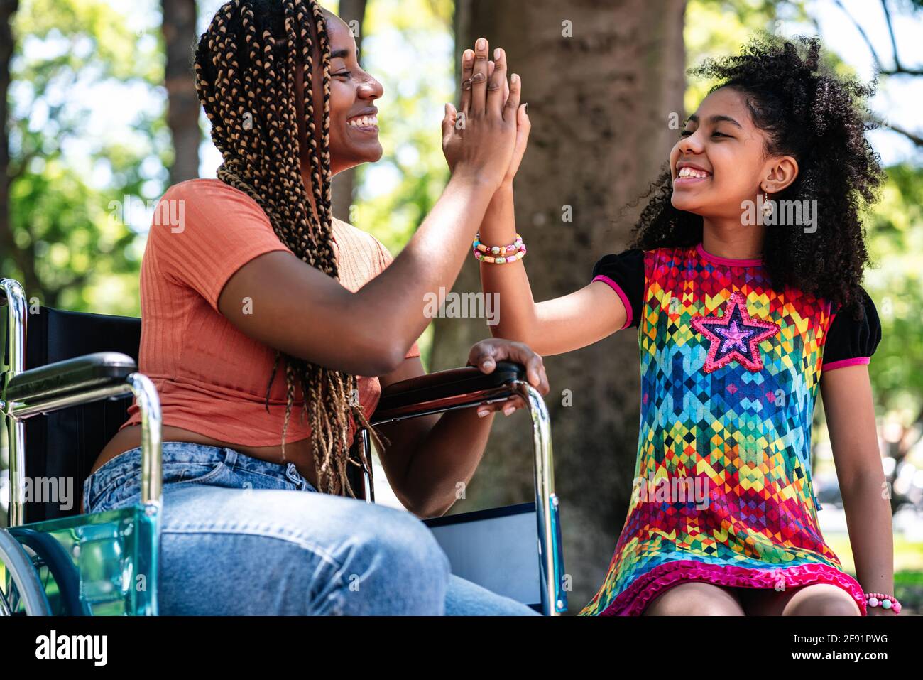 Femme en fauteuil roulant au parc avec sa fille. Banque D'Images