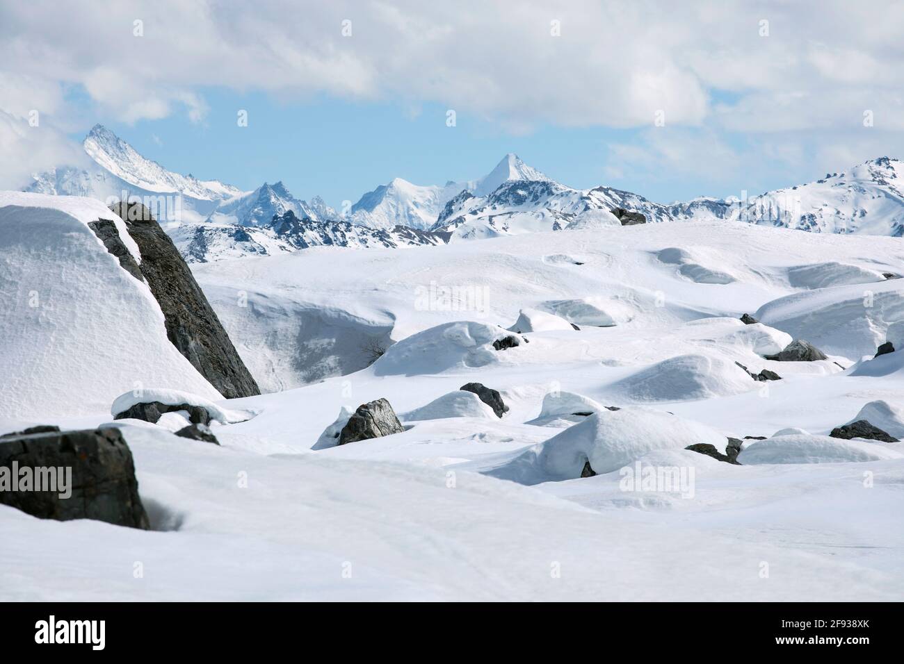 Paysage d'hiver, montagnes enneigées avec paysage nuageux, ciel bleu. Pierres au sommet de la montagne couvertes de neige. Sommets enneigés de l'alp suisse Banque D'Images