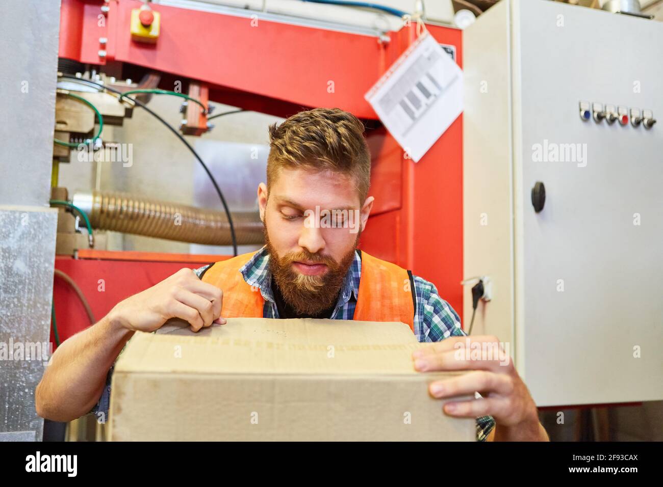 Le préparateur de commande dans l'entrepôt vérifie les marchandises entrantes dans l'emballage à gestion de l'entrepôt Banque D'Images