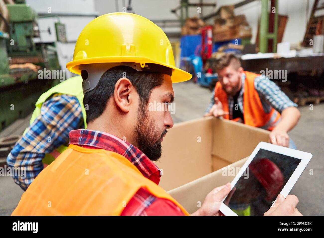 Le préparateur de commande vérifie la commande ou la commande sur le Tablette PC au service d'expédition de l'usine Banque D'Images