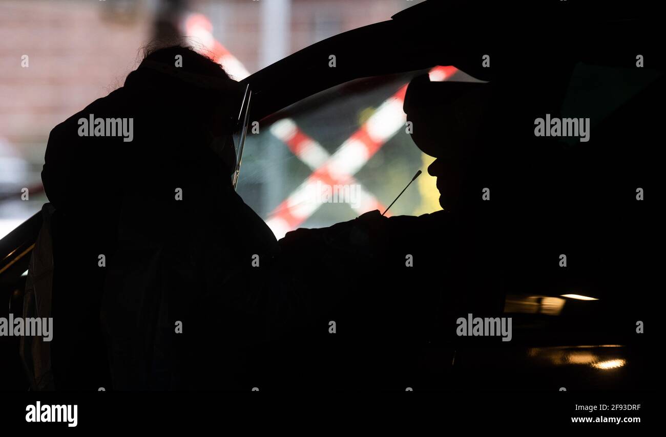 Hanovre, Allemagne. 16 avril 2021. Les aides testent les occupants de la voiture pour le virus corona avec des tests rapides au centre d'essai du zoo. L'Institut Robert-Koch (RKI) continue de signaler une augmentation des nouvelles infections de corona en Allemagne. Credit: Julian Stratenschulte/dpa/Alay Live News Banque D'Images