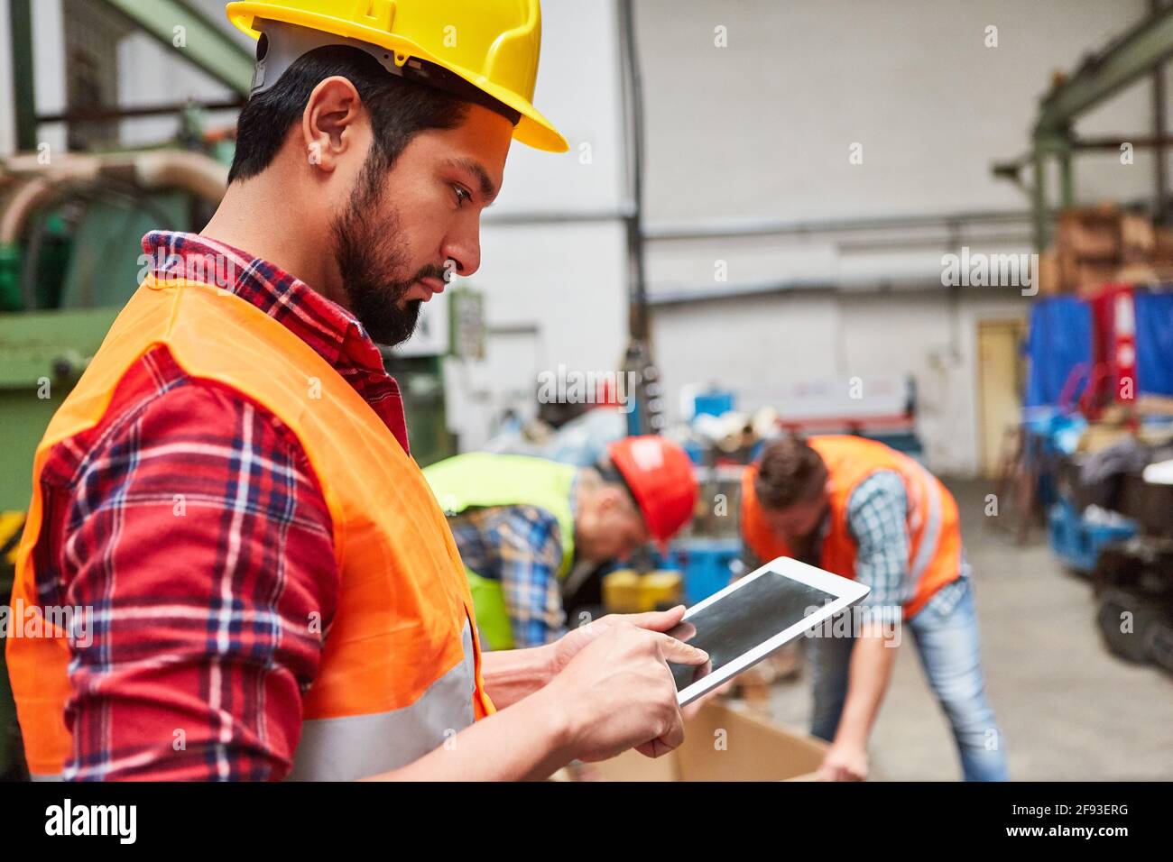 Le préparateur de commande avec tablette vérifie la livraison dans l'entrepôt de la compagnie d'expédition Banque D'Images