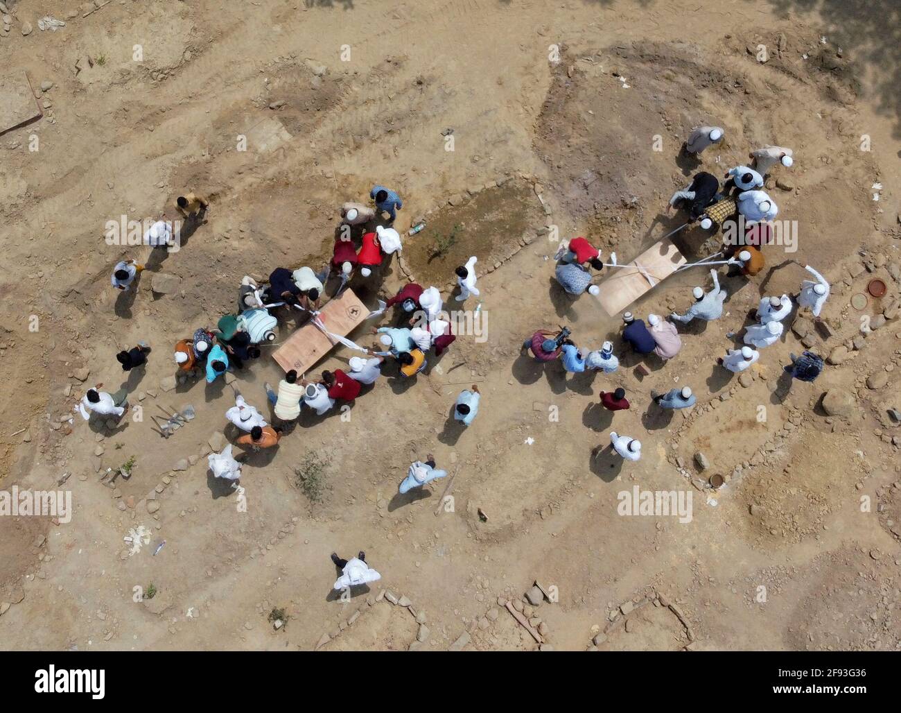 Les gens enterrent les cadavres de victimes qui sont mortes à cause de la maladie du coronavirus (COVID-19), dans un cimetière à New Delhi, en Inde, le 16 avril 2021. Photo prise avec un drone. REUTERS/Siddiqui danois Banque D'Images
