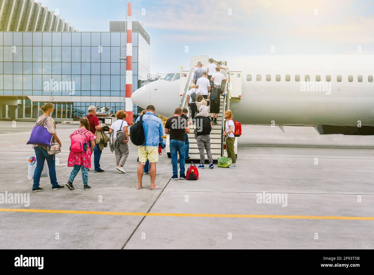 Embarquement des passagers à bord de l'avion. Les personnes avec leurs bagages vont monter les escaliers jusqu'à la cabine de l'avion. Avion passager. Concept de voyage et de tourisme. Pointe moderne Banque D'Images