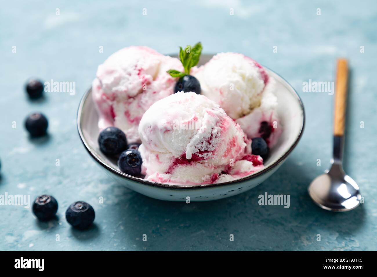 Yaourt maison et glace aux myrtilles avec myrtille naturelle un bol sur fond bleu rugueux Banque D'Images