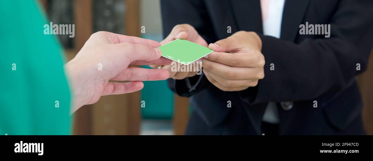 Le directeur de l'hôtel en costume noir reçoit une carte de chambre du client. Gros plan Banque D'Images