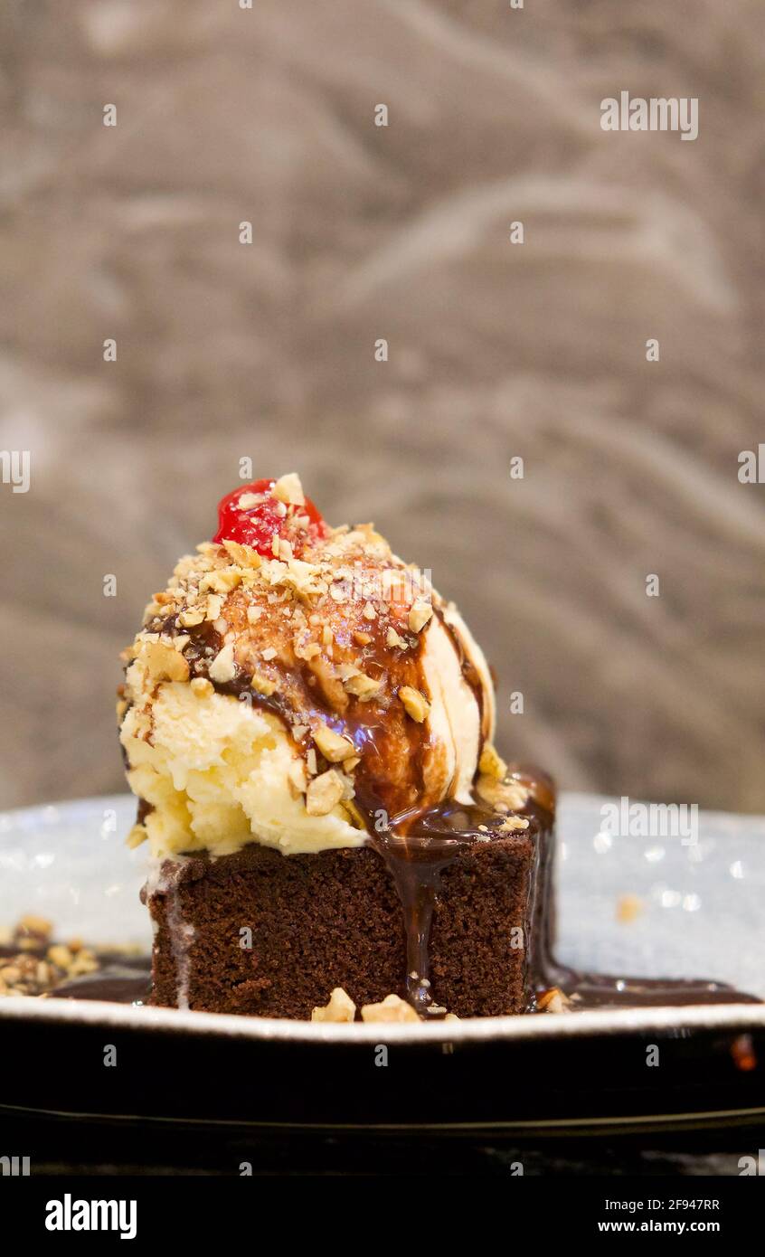 Glace A La Vanille Nappee De Sauce Au Chocolat Et De Noix Ecrasees Servi Avec Un Gateau Au Brownie Photo Stock Alamy