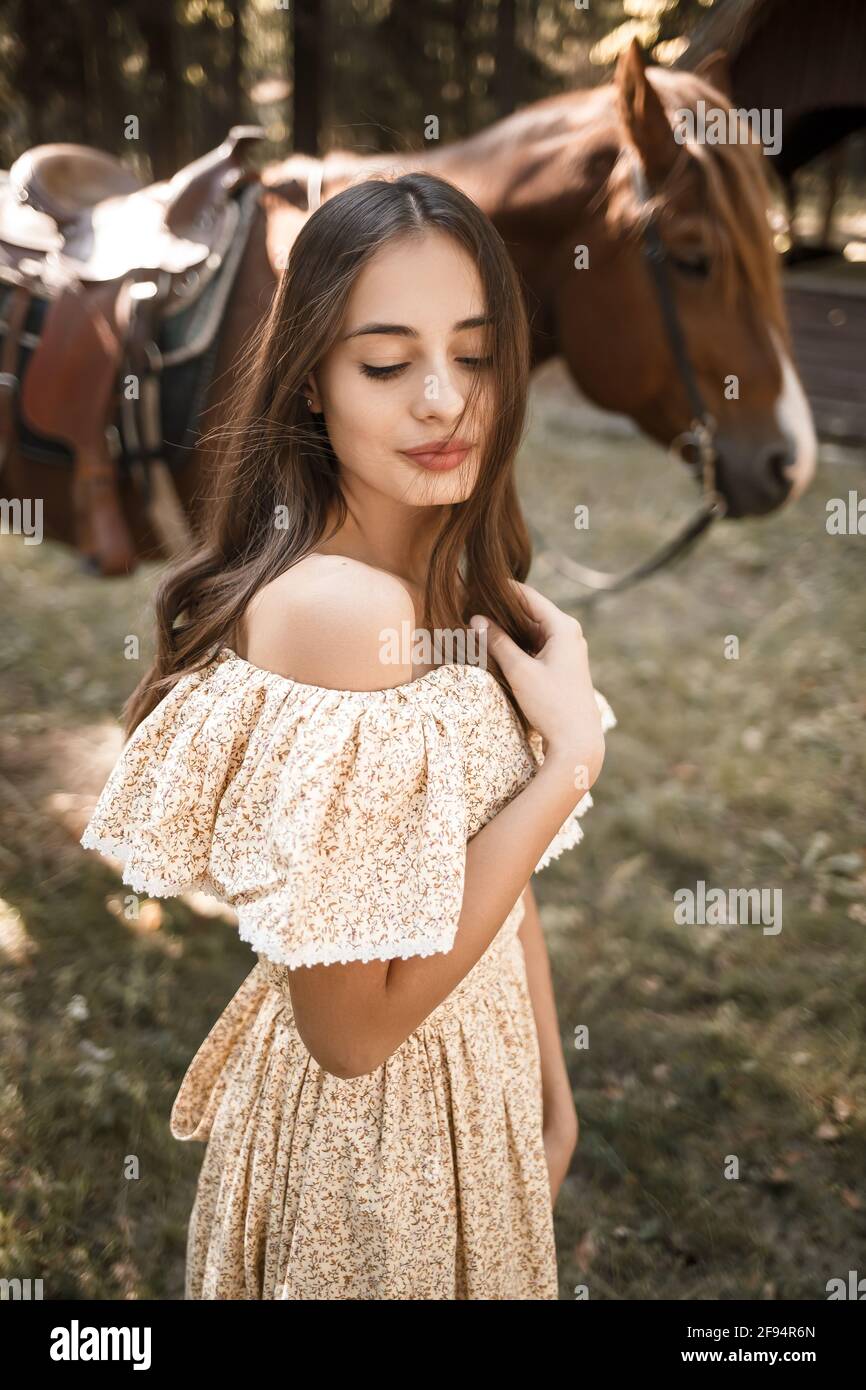 Une belle jeune fille habillée dans une robe se tient près un cheval dans  la forêt Photo Stock - Alamy