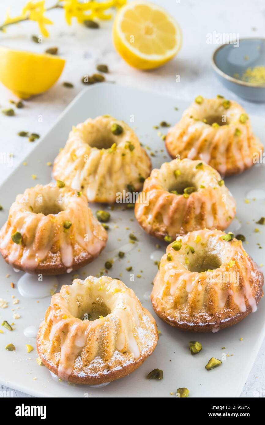 Petits gâteaux au citron faits maison (muffins) sur fond blanc, verticaux Banque D'Images