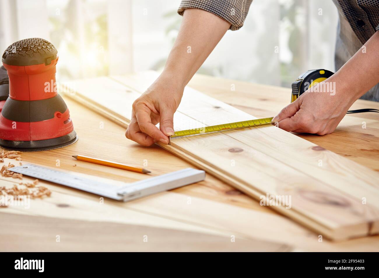 Carpenter travaille avec le bois dans l'atelier. Une femme travaille dans un atelier de menuiserie. Travaux de construction. Banque D'Images