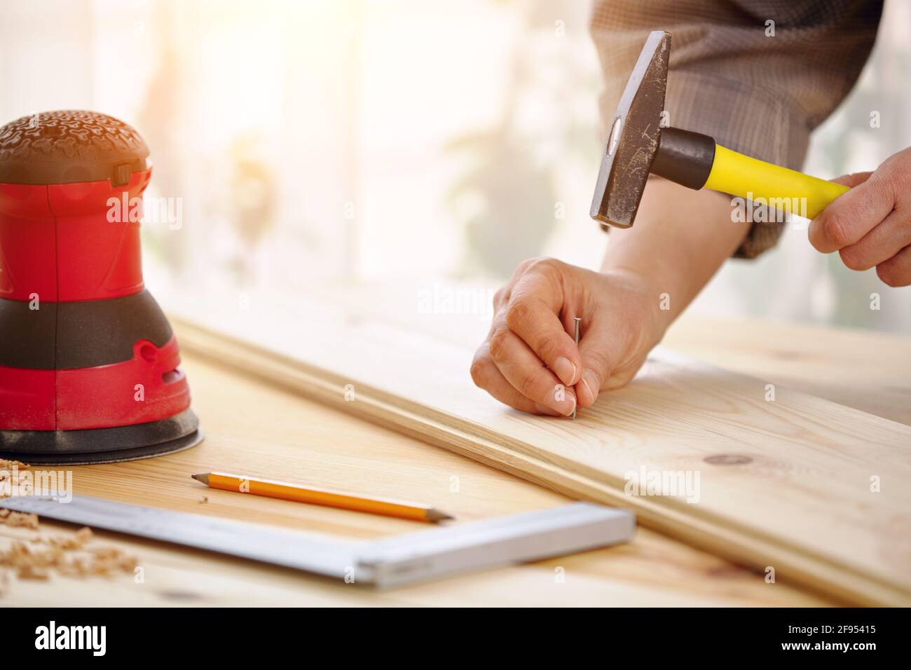 Carpenter travaille avec le bois dans l'atelier. Une femme travaille dans un atelier de menuiserie. Travaux de construction. Banque D'Images