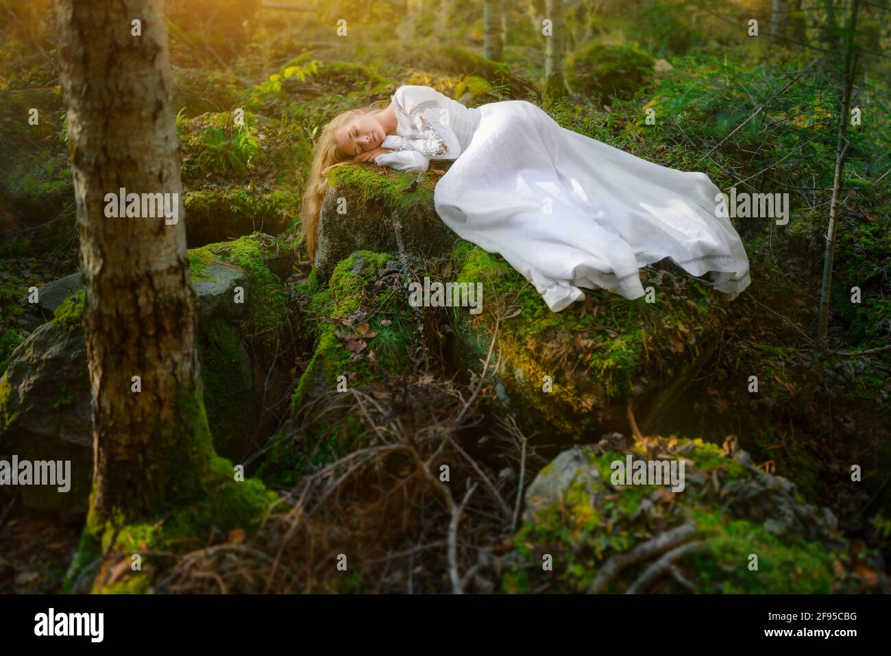 Belle jeune femme dans une robe blanche au milieu d'une forêt Banque D'Images