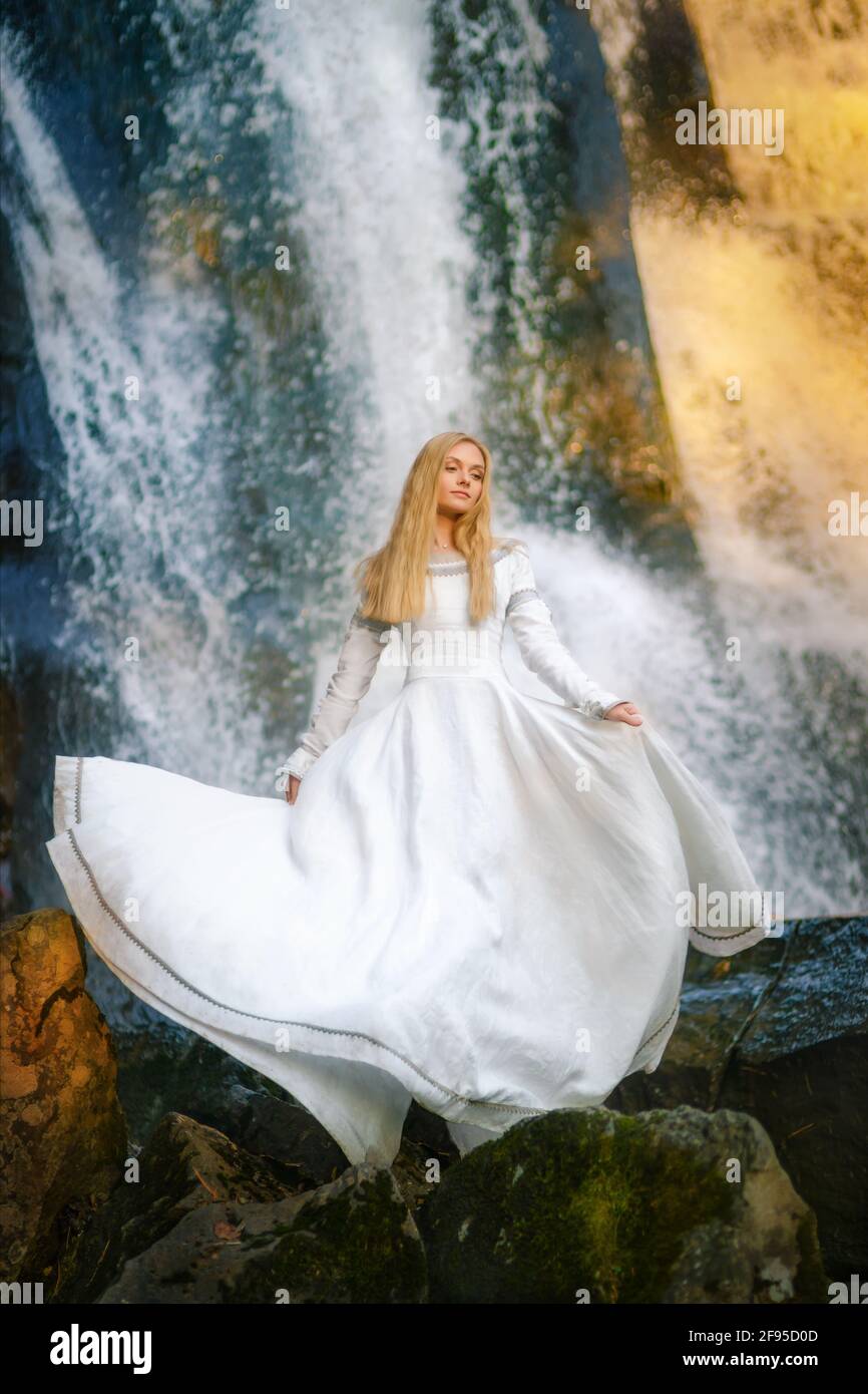 Belle jeune femme dans une robe blanche au milieu d'une forêt Banque D'Images