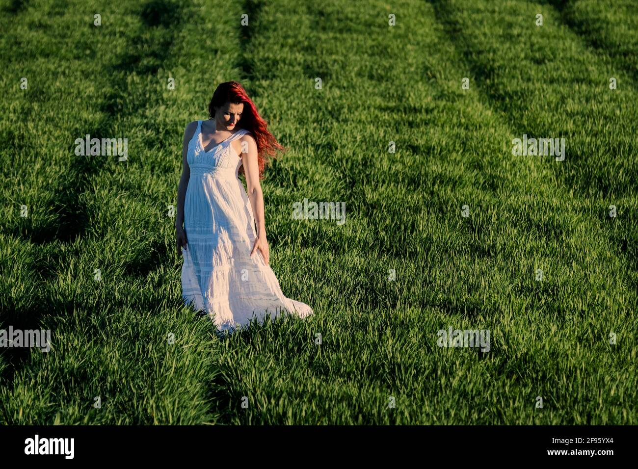 Femme d'âge moyen en robe blanche aux herbes vertes, mode de vie sain Banque D'Images