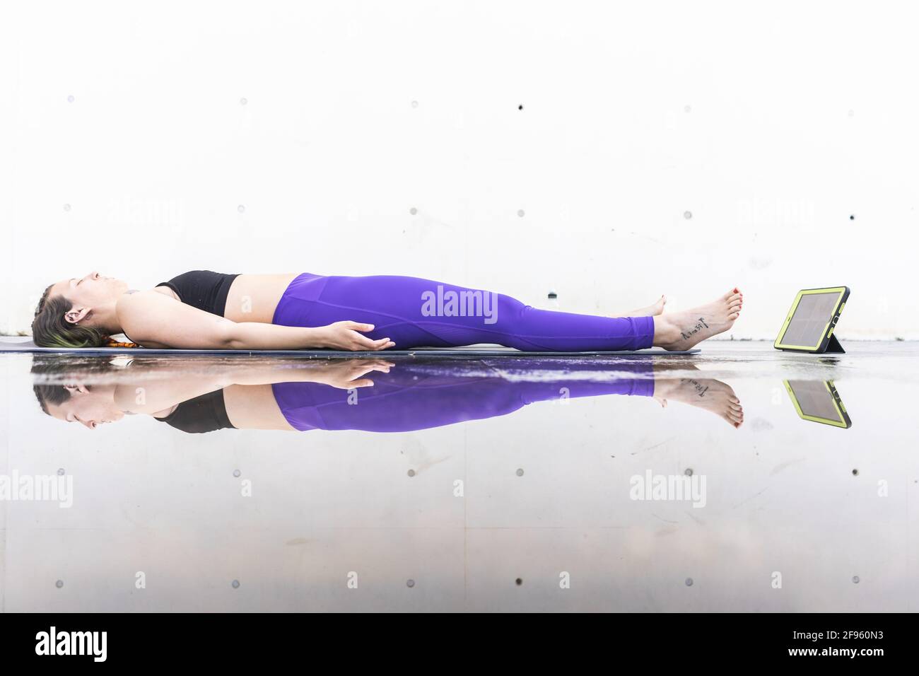 Athlète femme faisant la posture savasana pendant un yoga en ligne classe Banque D'Images