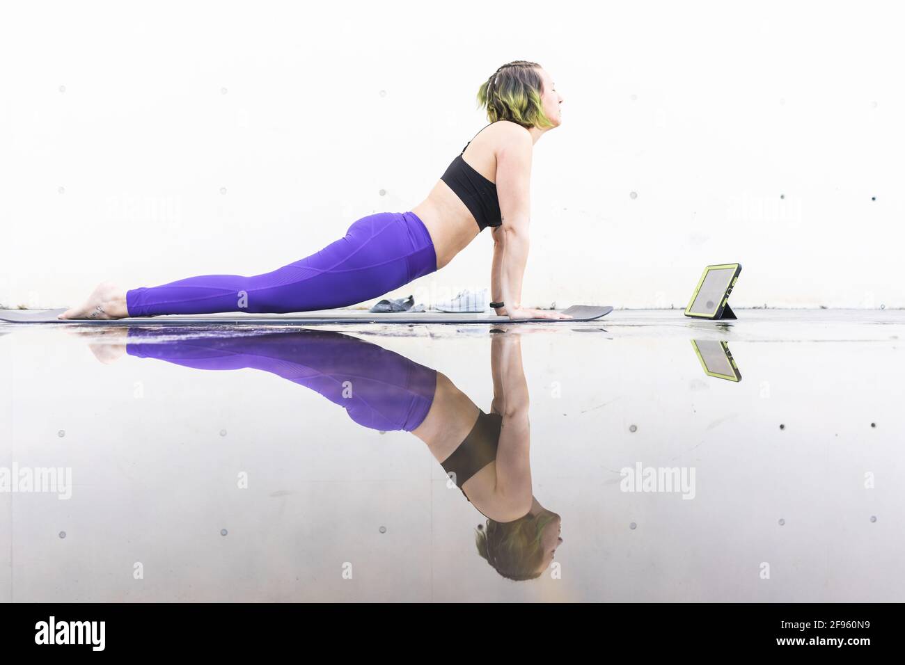 Une athlète féminine exécutant la posture du chien face vers le haut pendant un classe Banque D'Images