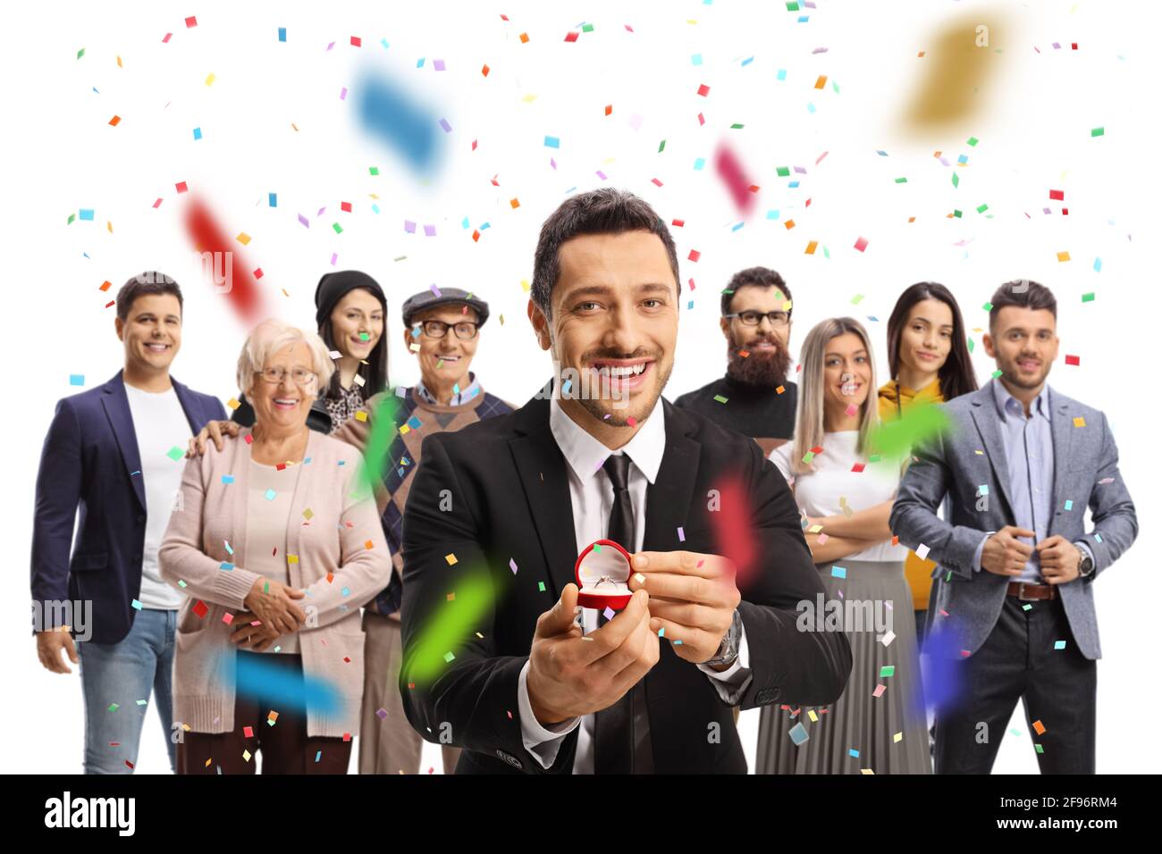 Jeune homme tenant un anneau dans une boîte et célébrant engagement avec la famille autour de isolé sur fond blanc Banque D'Images