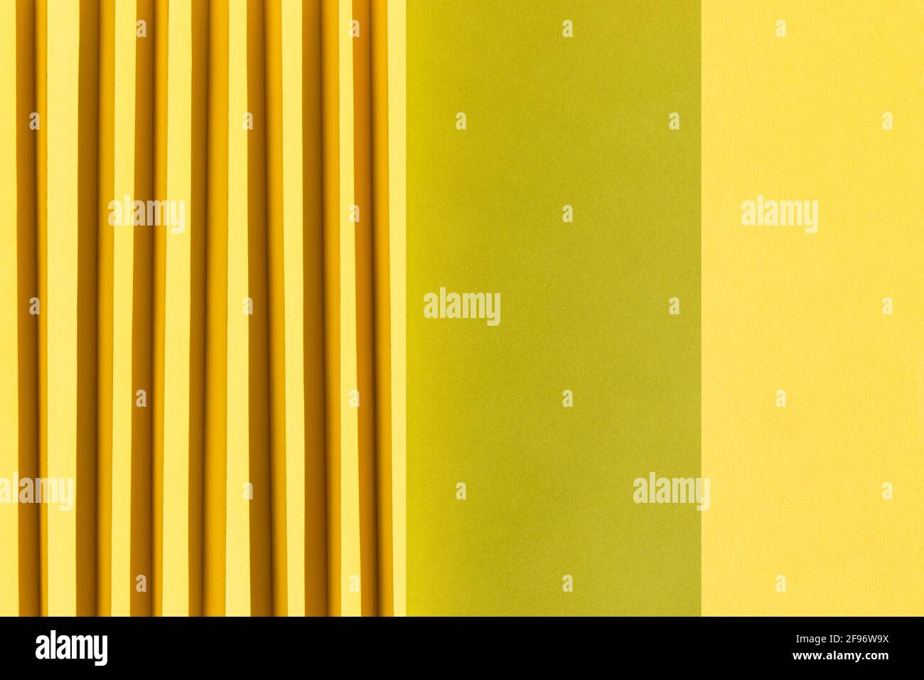 Texture abstraite de papier de couleur jaune et verte. Papier plié avec des ombres du soleil, des formes géométriques et des lignes. Arrière-plan minimaliste. Pose à plat. COP Banque D'Images