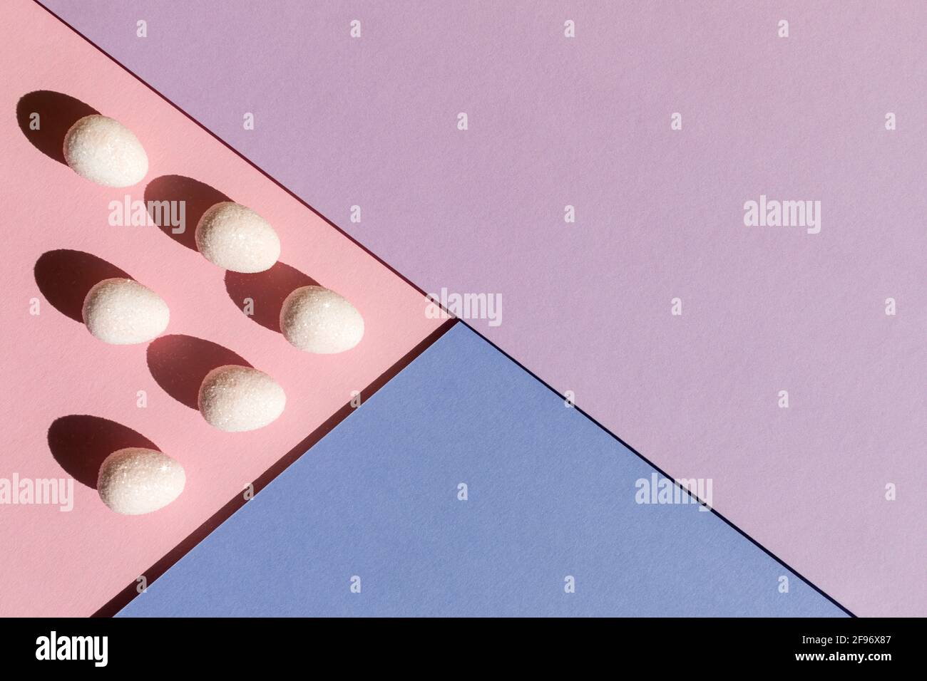 Résumé disposition de Pâques avec œufs et ombres d'été tendance sur fond rose pastel, bleu et violet à trois tons. Concept de vacances de printemps minimal. Copier Banque D'Images