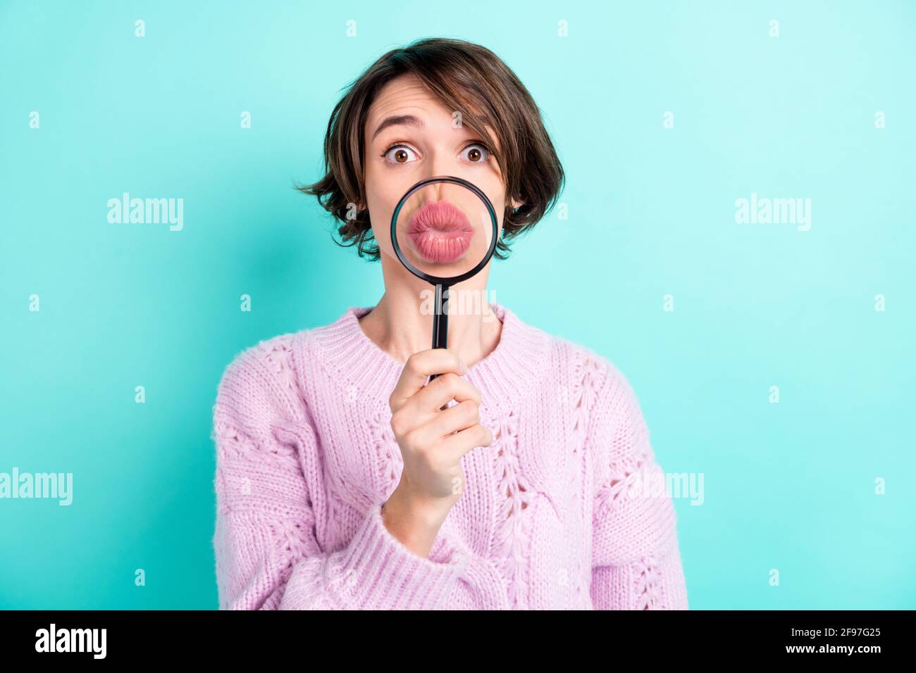 Photo de douce drôle jeune femme porte violet chandail agrandissant loupe bouted lèvres isolé couleur turquoise arrière-plan Banque D'Images