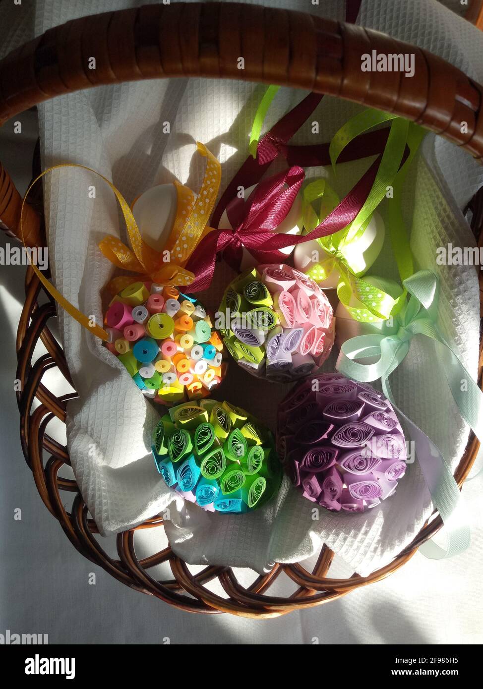 Œufs décorés de rubans et de papier coloré dans un panier Banque D'Images